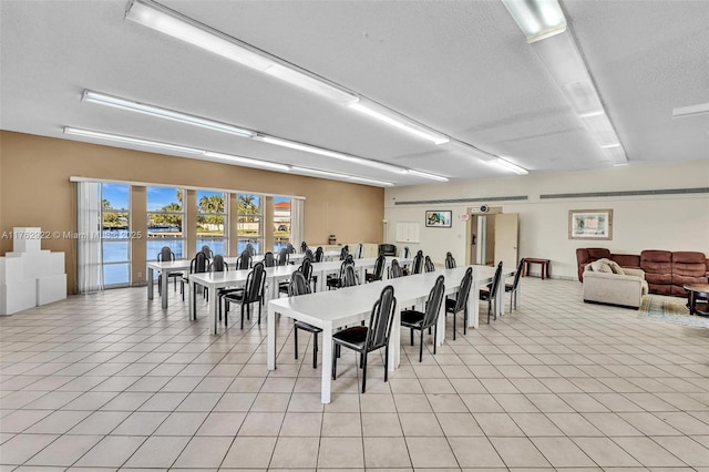 dining space with a textured ceiling and light tile patterned flooring