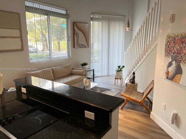 living room with stairway, baseboards, and wood finished floors