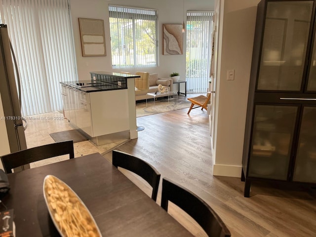 dining space featuring baseboards and light wood-type flooring