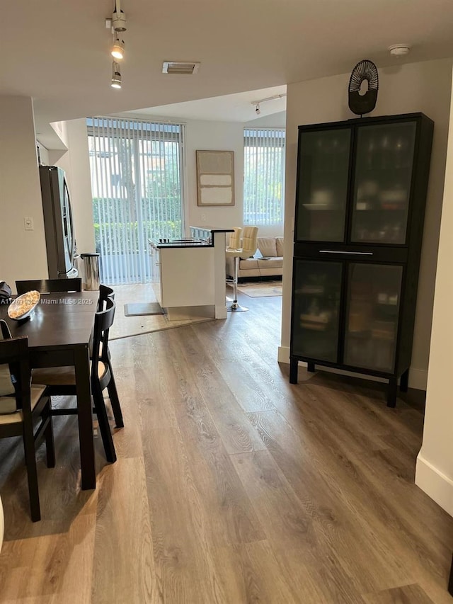 dining room with visible vents, light wood-style flooring, and baseboards