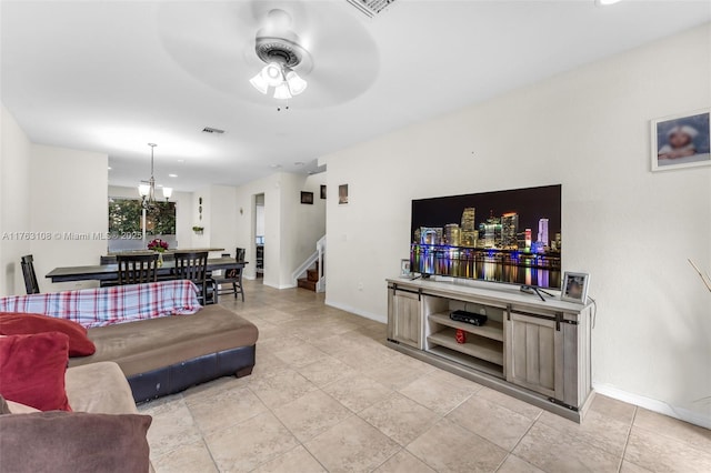 living room with stairway, visible vents, baseboards, light tile patterned flooring, and ceiling fan with notable chandelier