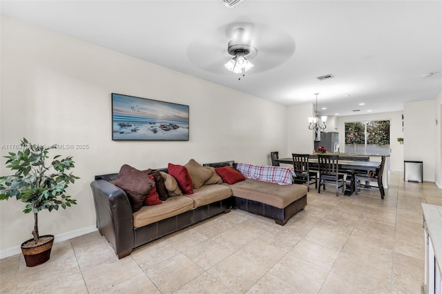 living area with visible vents, ceiling fan with notable chandelier, and baseboards