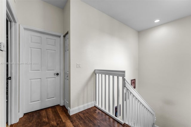 hall featuring an upstairs landing, recessed lighting, baseboards, and dark wood-style flooring