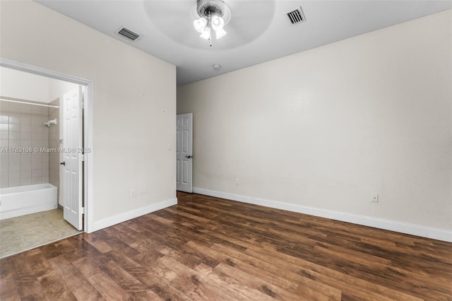 unfurnished bedroom featuring ceiling fan, wood finished floors, visible vents, and baseboards