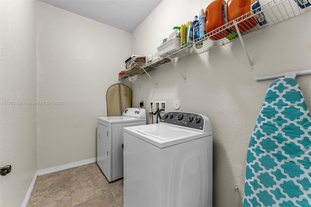 laundry room featuring laundry area, washing machine and dryer, and baseboards