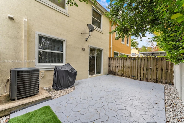 view of patio / terrace featuring area for grilling, central AC unit, and fence