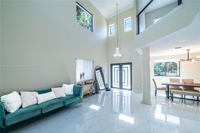 living room with baseboards, ornate columns, an inviting chandelier, crown molding, and marble finish floor