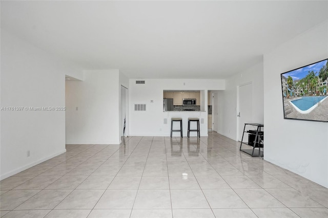 unfurnished living room with visible vents and light tile patterned flooring