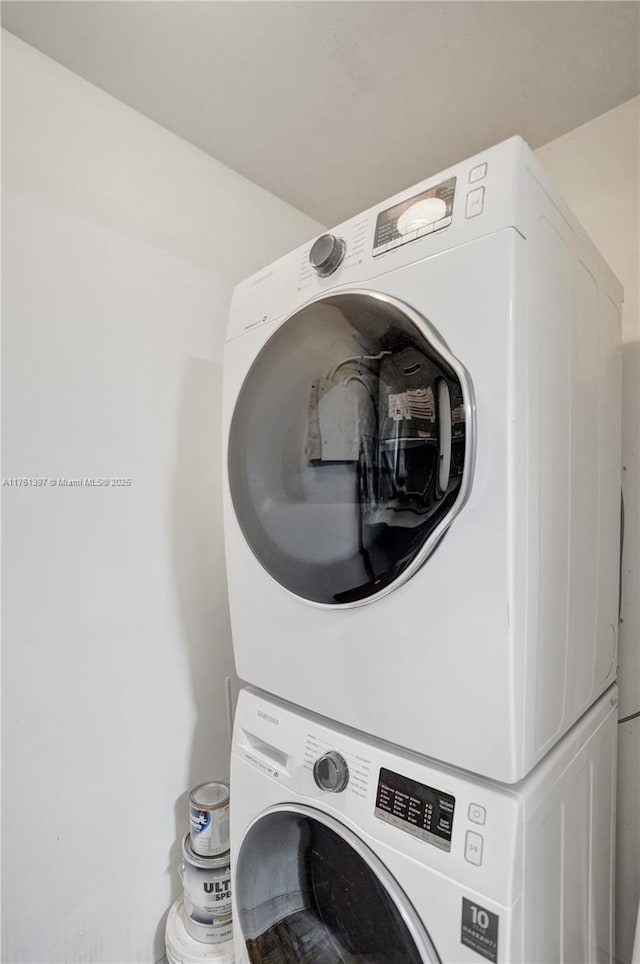 clothes washing area with laundry area and stacked washer and dryer