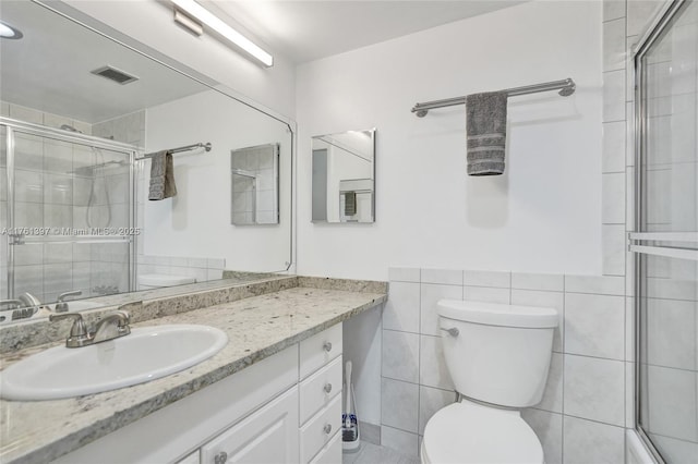 bathroom with visible vents, toilet, tile walls, and a shower stall