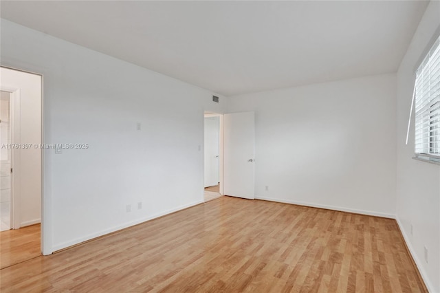 spare room with visible vents, light wood-style flooring, and baseboards