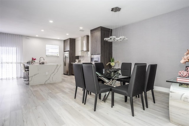 dining room with recessed lighting, light wood-type flooring, and baseboards