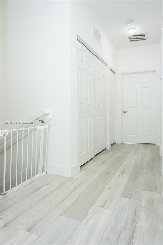 interior space with wood finished floors, visible vents, and baseboards