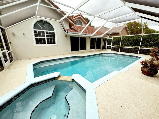 view of swimming pool featuring a patio area, glass enclosure, and a pool with connected hot tub