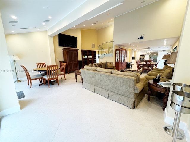 living room featuring visible vents, recessed lighting, baseboards, a towering ceiling, and stairs