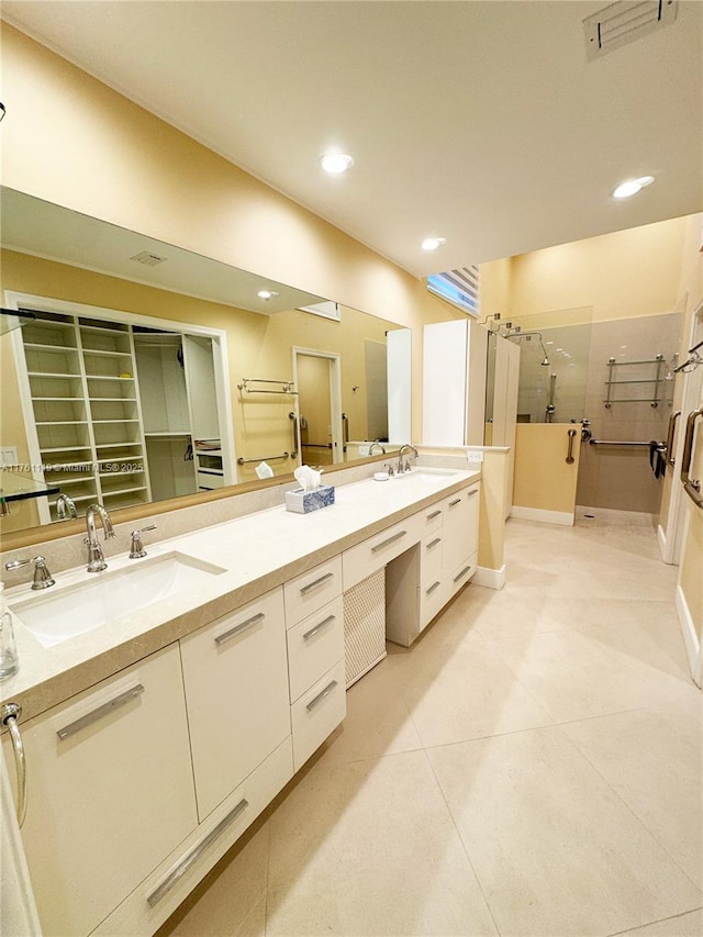 bathroom featuring double vanity, recessed lighting, a shower stall, and a sink