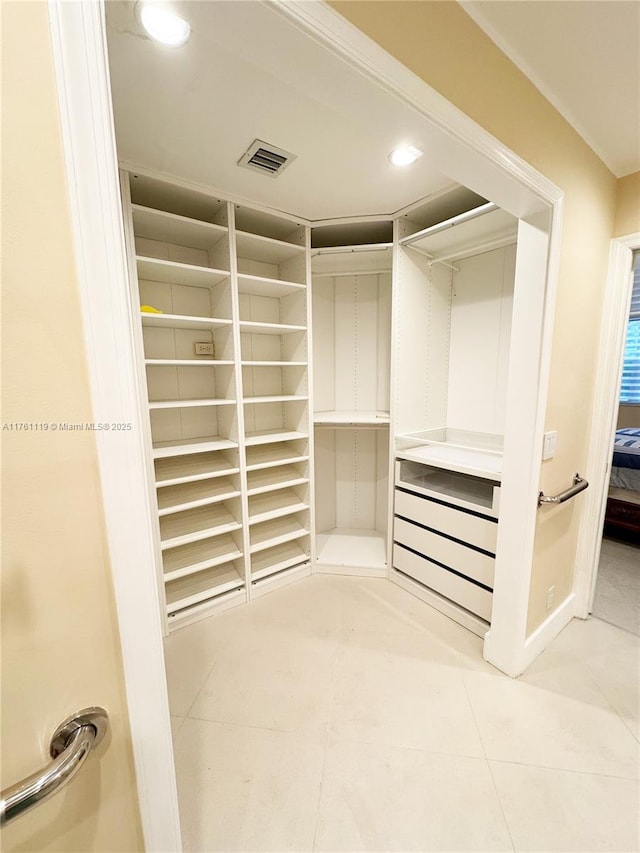 spacious closet with light tile patterned floors and visible vents