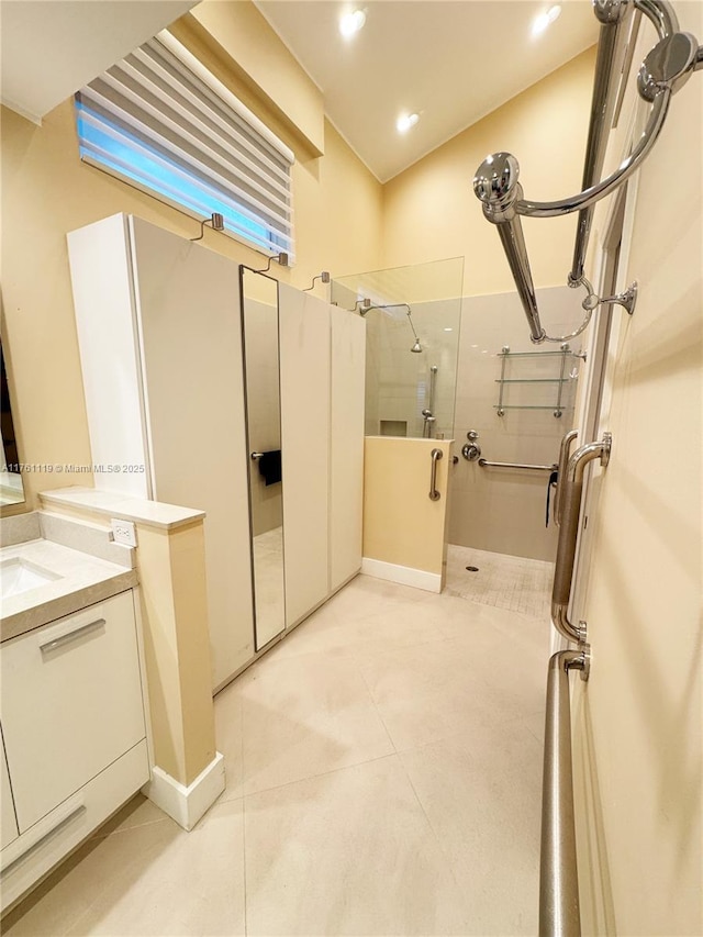 bathroom with tile patterned floors, walk in shower, and vanity