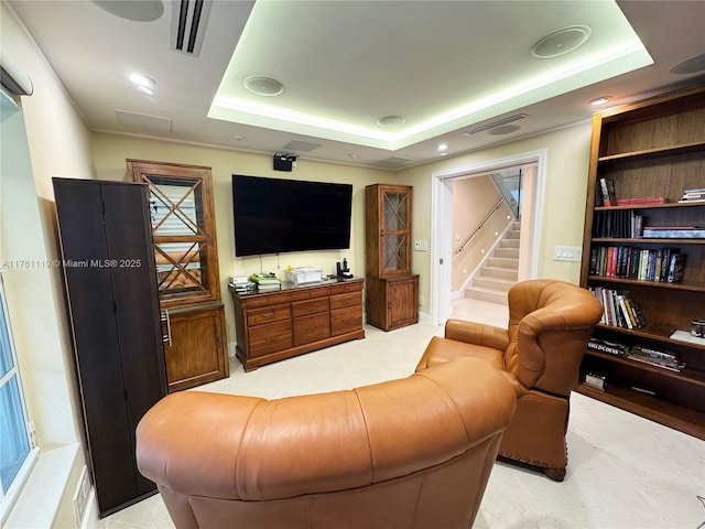 living room featuring visible vents, stairway, and a raised ceiling