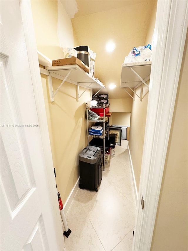 walk in closet with light tile patterned floors