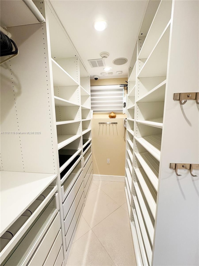 walk in closet with light tile patterned floors