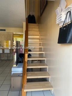 stairway featuring tile patterned flooring