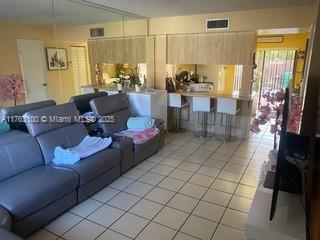 living room featuring visible vents and light tile patterned flooring