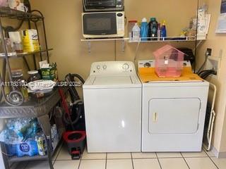 washroom with tile patterned flooring, laundry area, and separate washer and dryer