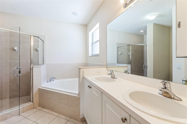 full bath featuring a sink, a stall shower, a bath, and tile patterned flooring