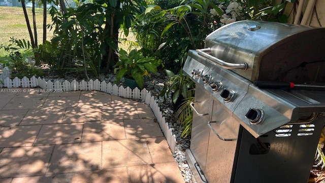 view of patio featuring a grill and fence