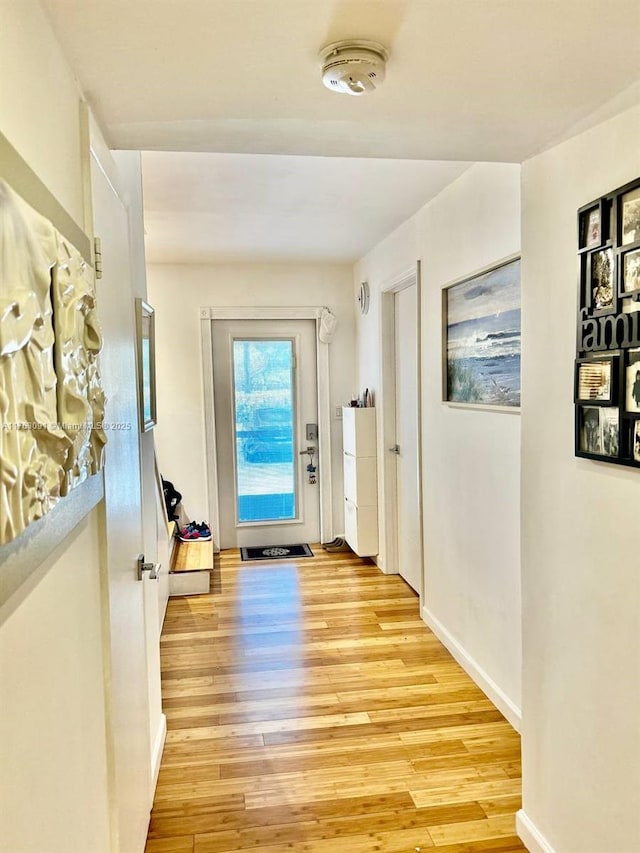 entryway featuring baseboards and light wood finished floors