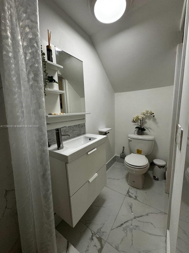 full bath with vanity, baseboards, lofted ceiling, toilet, and marble finish floor