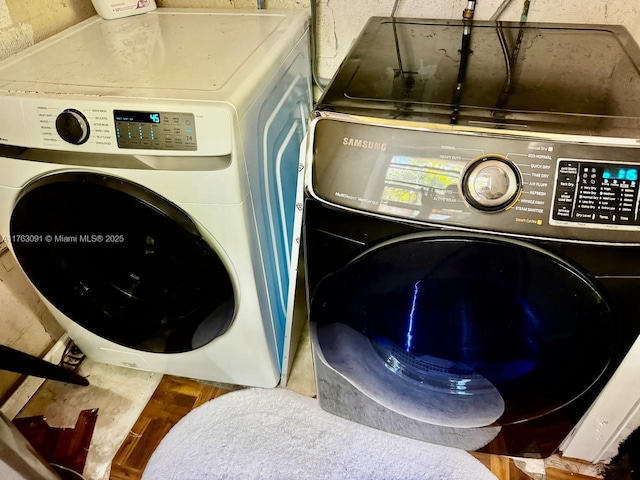 laundry room featuring wood finished floors, laundry area, and washer and clothes dryer