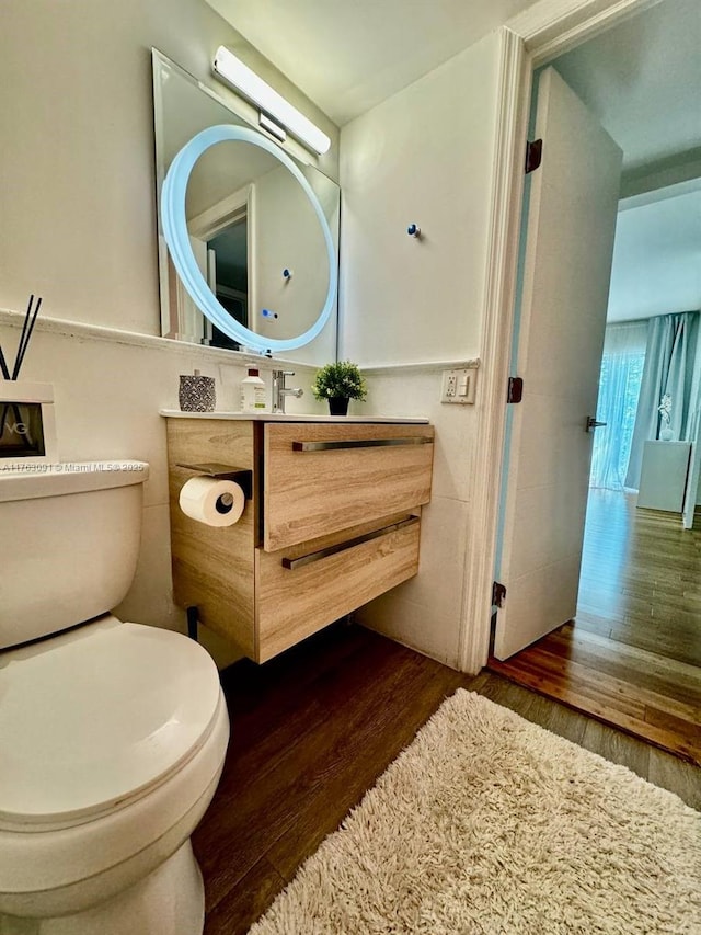 bathroom featuring vanity, toilet, and wood finished floors