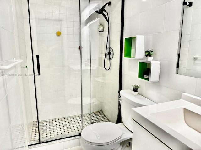 bathroom featuring vanity, tile walls, toilet, and a stall shower