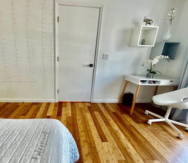 office space with baseboards and wood-type flooring