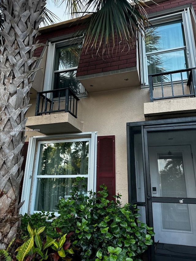 property entrance with stucco siding and a balcony