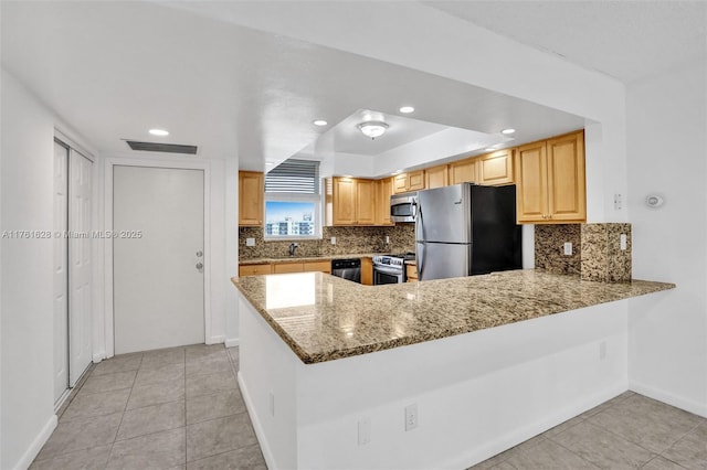 kitchen featuring light stone counters, visible vents, a peninsula, stainless steel appliances, and tasteful backsplash