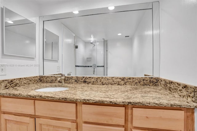 full bathroom featuring vanity, a shower stall, and recessed lighting