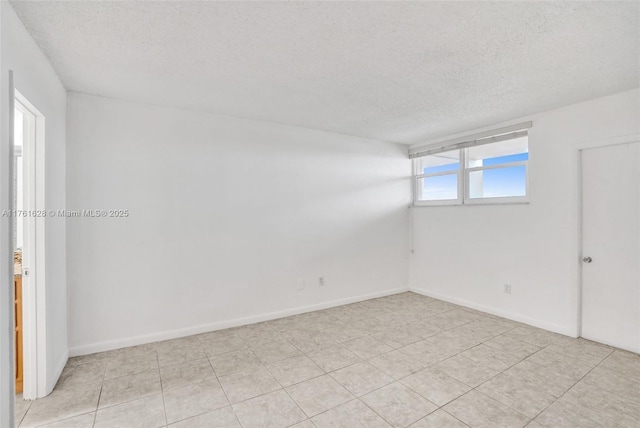 unfurnished room with a textured ceiling and baseboards