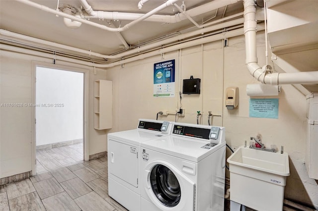 shared laundry area with washer and dryer and a sink