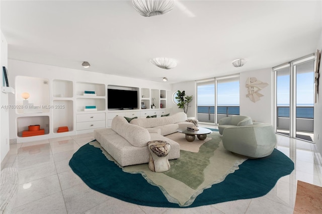 tiled living room featuring built in features and a wall of windows