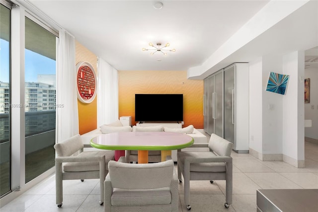 dining area with wallpapered walls, an accent wall, baseboards, a wall of windows, and light tile patterned flooring