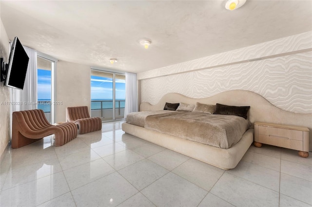 bedroom featuring access to exterior, tile patterned flooring, and a wall of windows