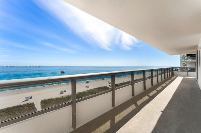 balcony featuring a beach view and a water view