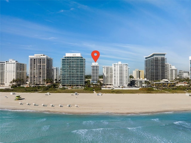 birds eye view of property featuring a view of city, a water view, and a beach view