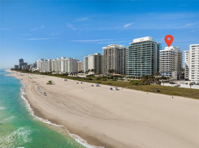 birds eye view of property with a view of city, a water view, and a beach view