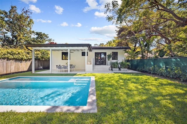 rear view of property featuring a fenced in pool, a fenced backyard, a yard, a ceiling fan, and a patio