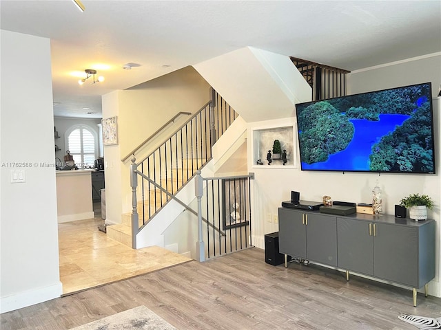 living area with stairway, wood finished floors, and baseboards