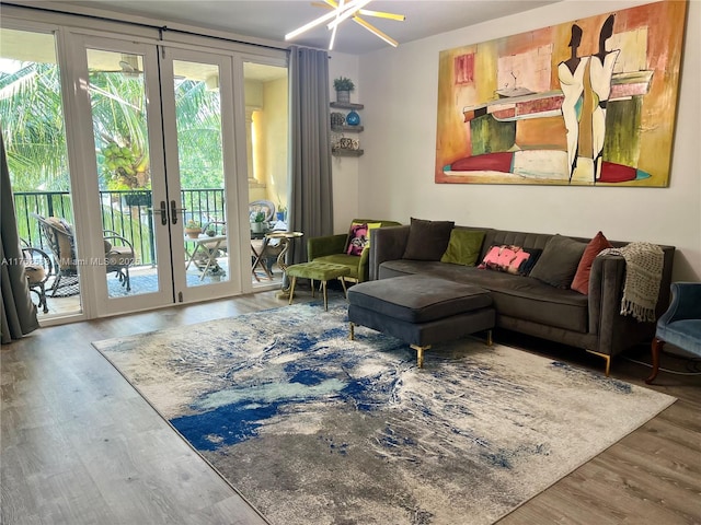 living room with french doors, a wall of windows, and wood finished floors